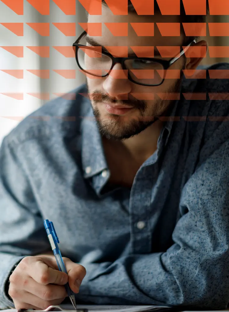 Young man working on laptop and taking notes