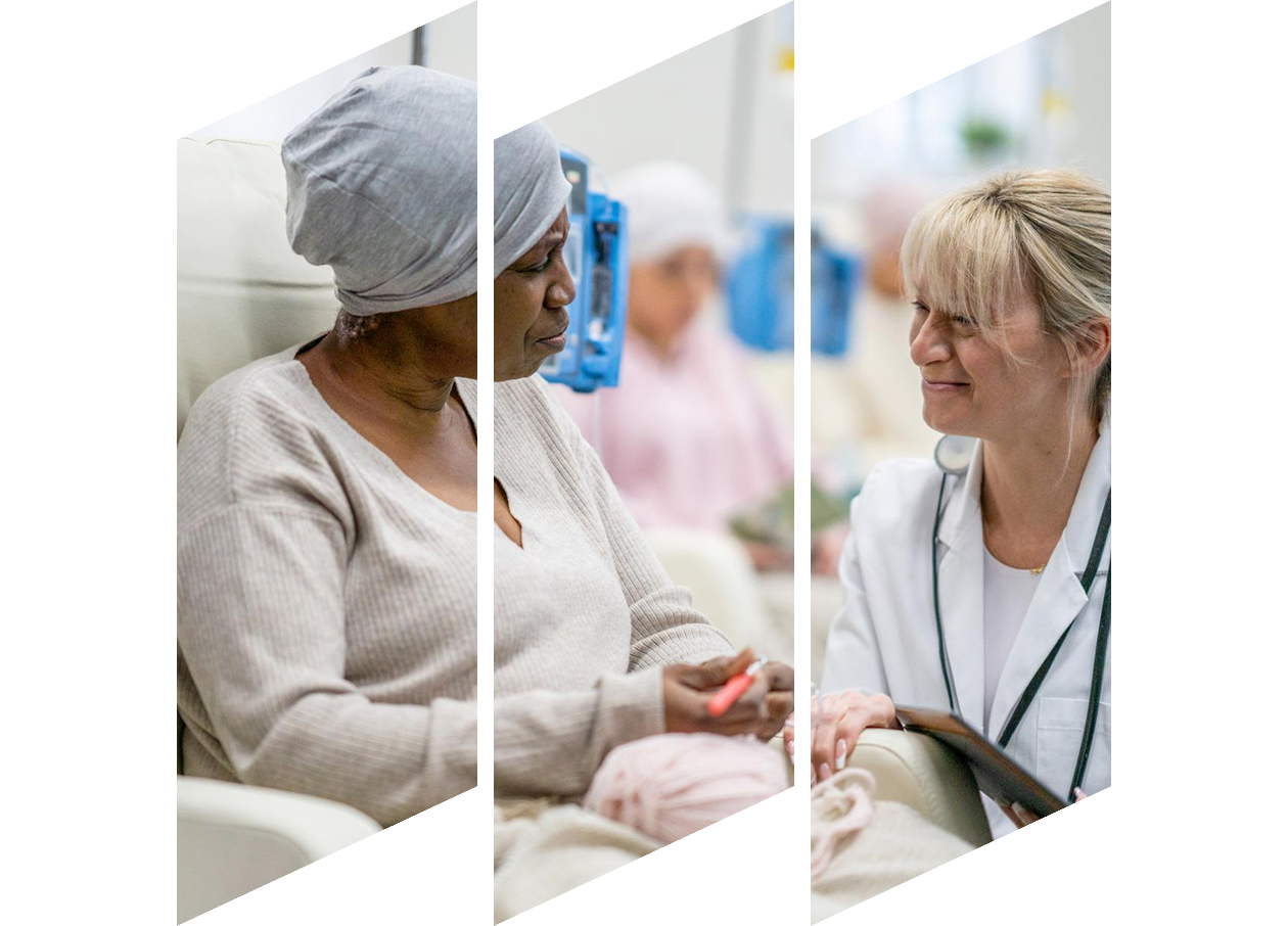 Female oncologist kneeling down in front of a female patient in a cancer clinic