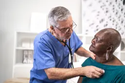 Doctor using a stethoscope to check the heartbeat of an elderly patient