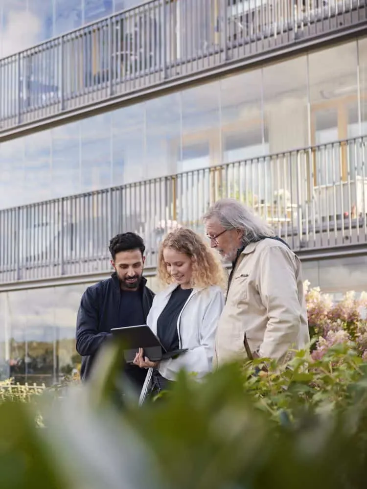 Men and woman with laptop in courtyard