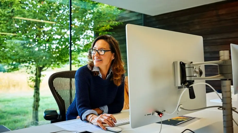 Happy mature businesswoman sitting at her desk