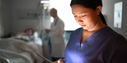 Female nurse using digital tablet at hospital room