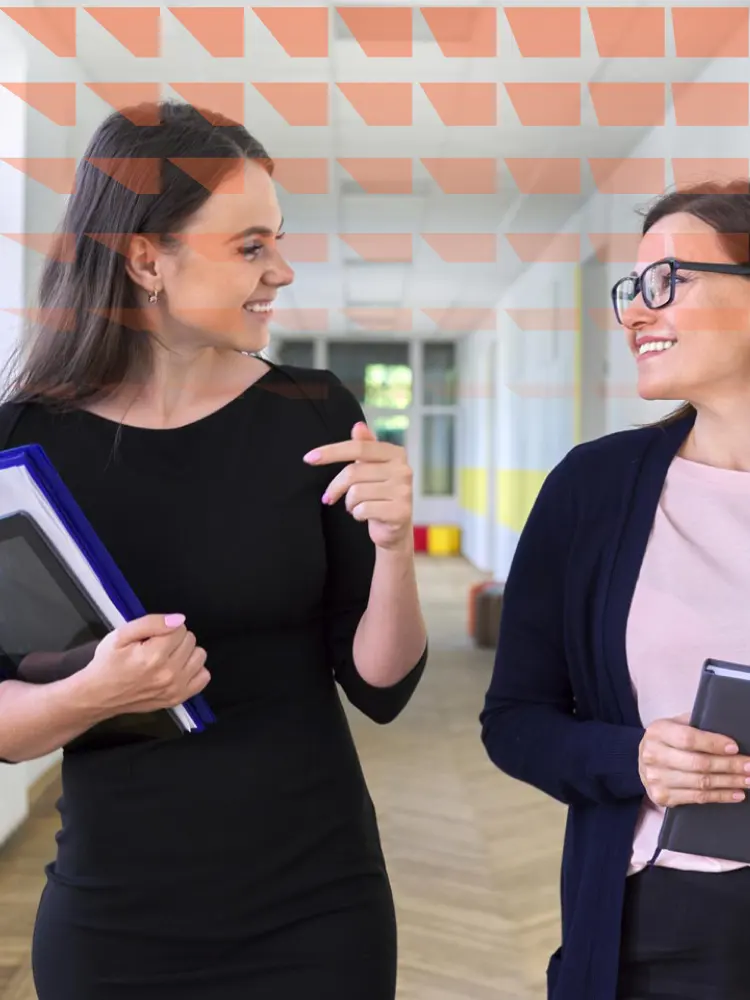 Two colleagues walking and talking whilst walking down corridor