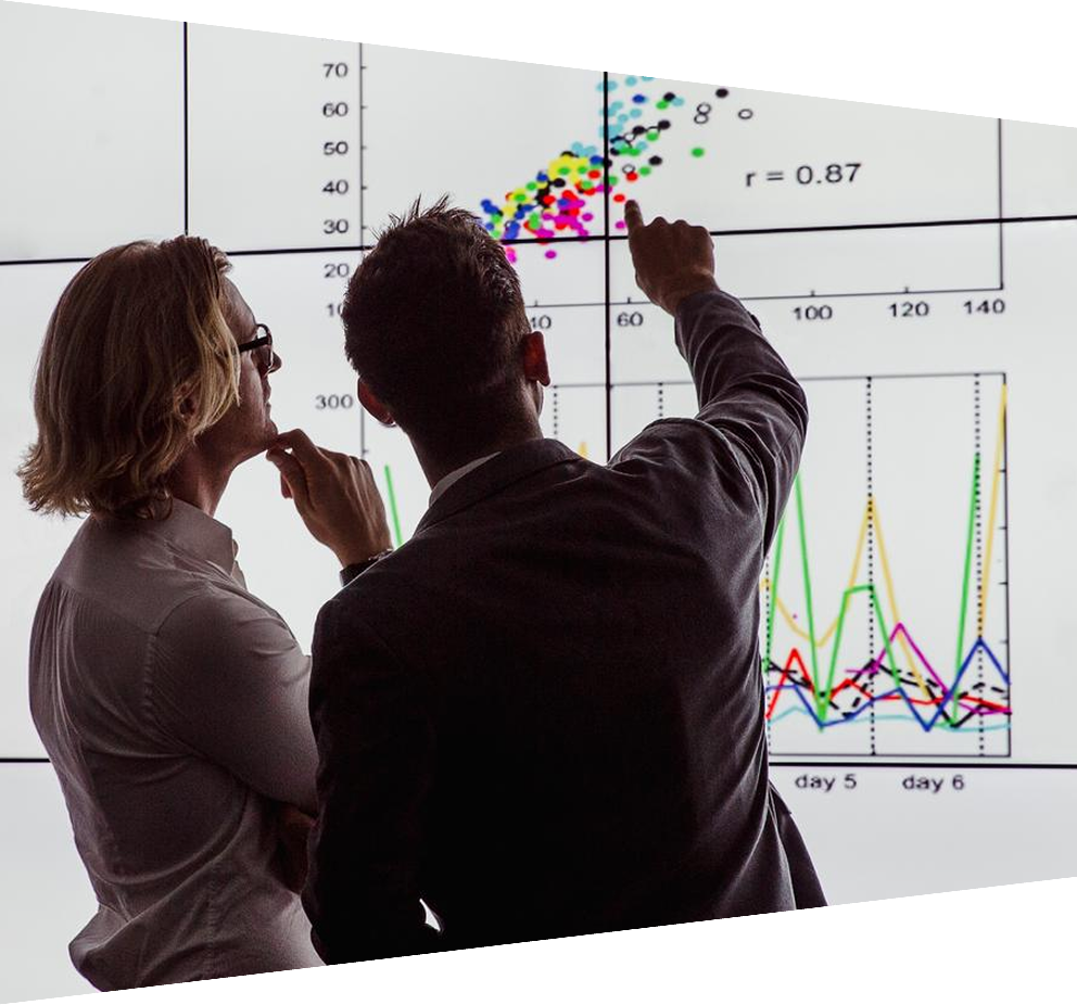 Business men in a dark room standing in front of a large data display