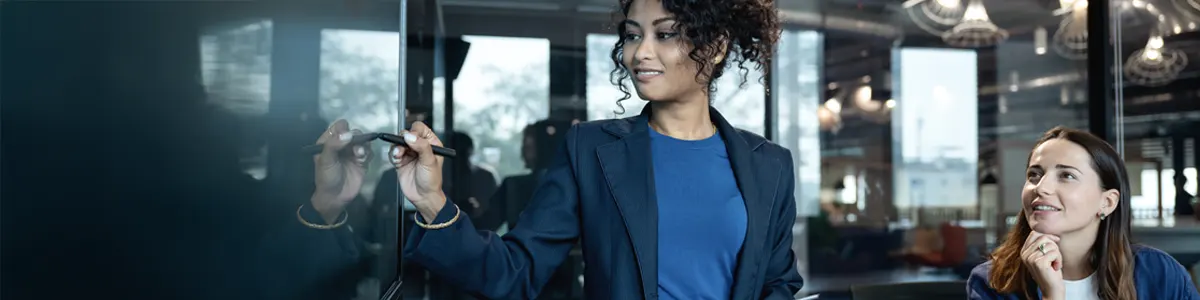 Female marketeer presenting data to colleague on a large digital display