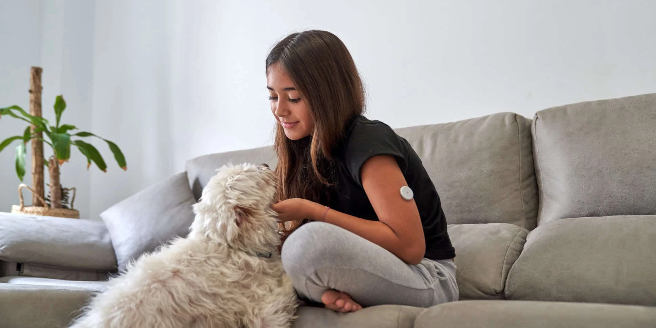 Teenage girl playing with her dog at home