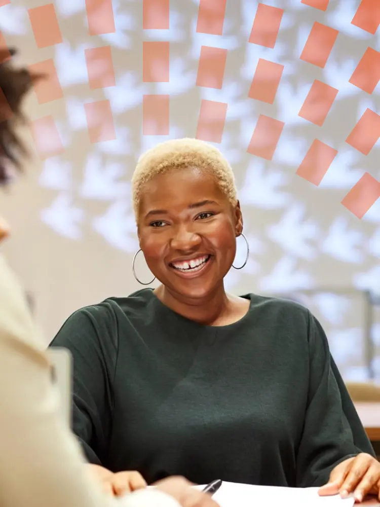 Smiling businesswoman discussing with colleagues at desk