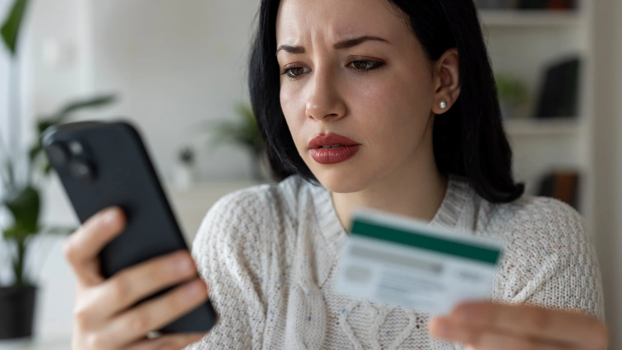 Woman Looking at Smartphone While Holding Credit Card