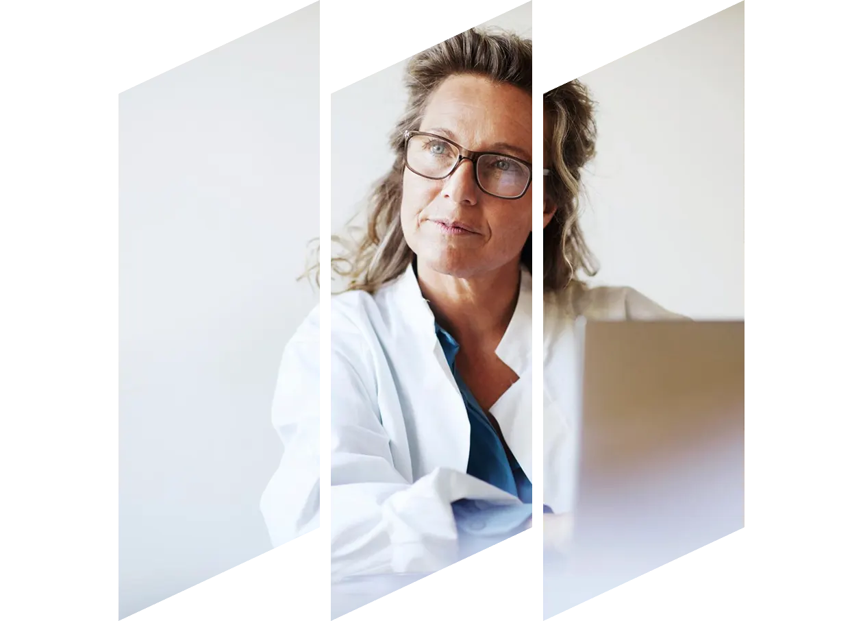 Thoughtful looking female doctor using laptop