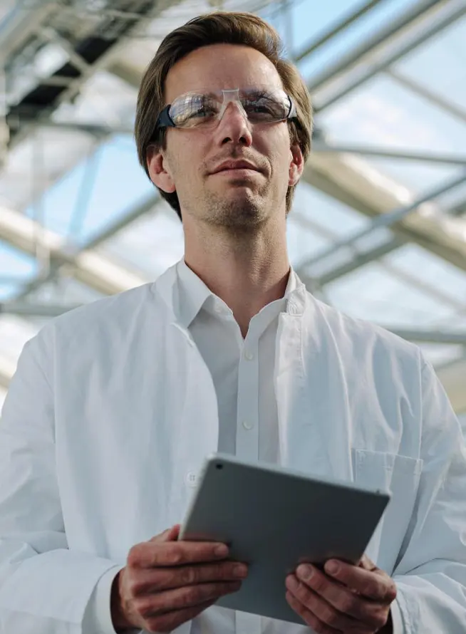 Confident scientist holding a digital tablet in a greenhouse