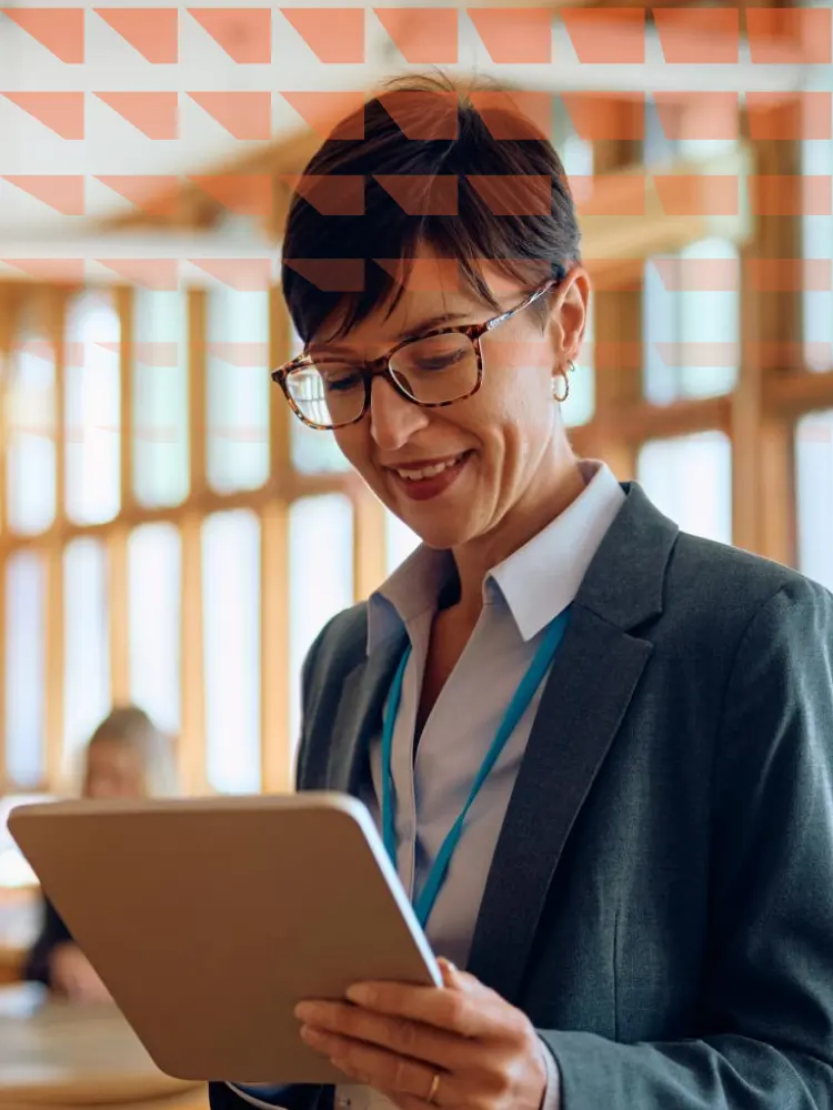 Happy high school teacher using digital tablet in the classroom