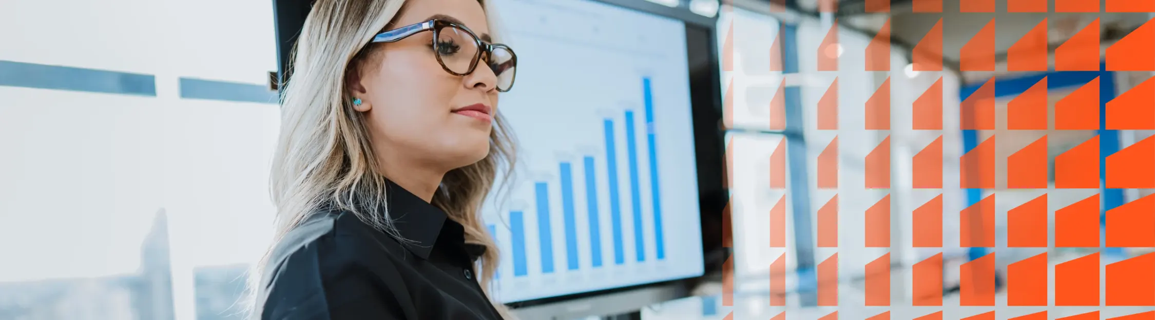 Professional reviewing a bar chart on a monitor in a modern office