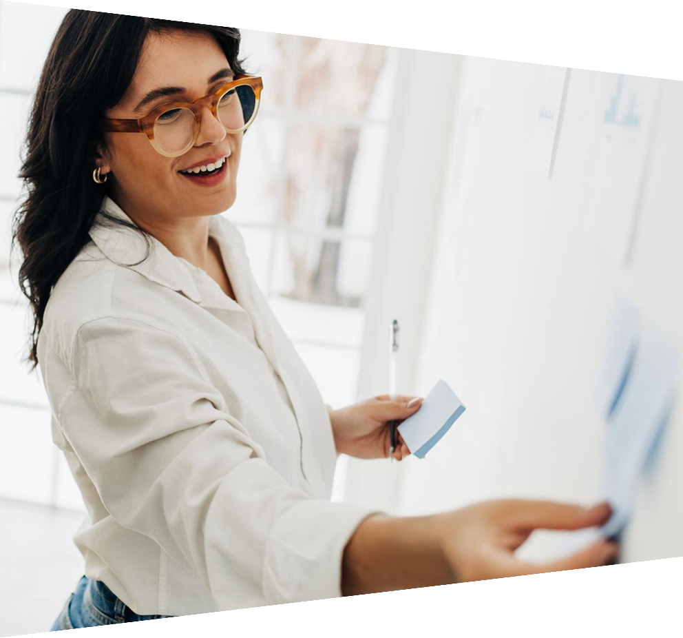 Happy business women creating a to do list using sticky notes