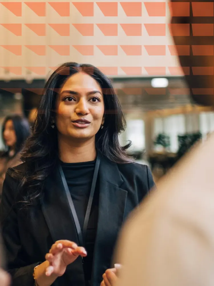 Young female entrepreneur discussing with delegates during networking event