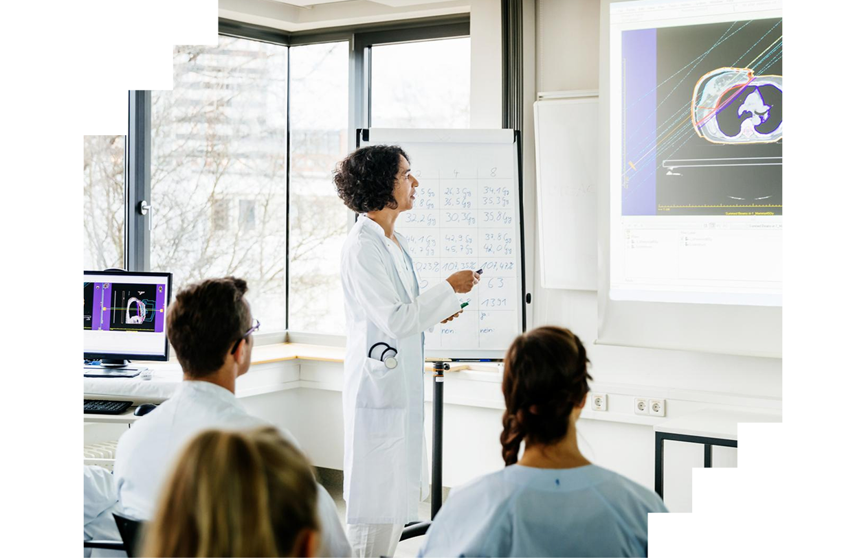A medical doctor going over some data projected on a whiteboard during a teaching seminar