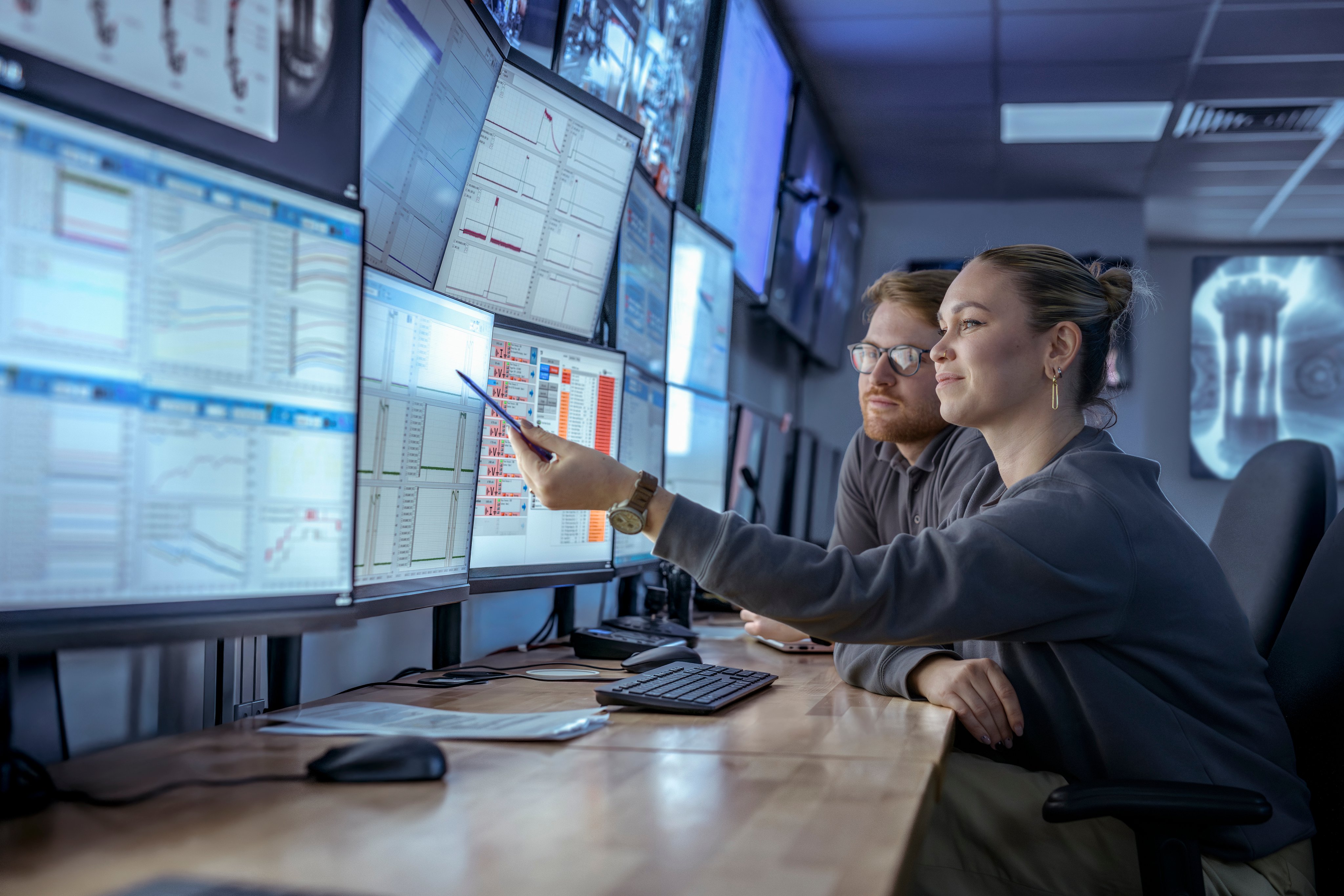 Scientist and Engineer inspecting data on screens in control room for high field spherical tokamak ST40 Nuclear Fusion reactor