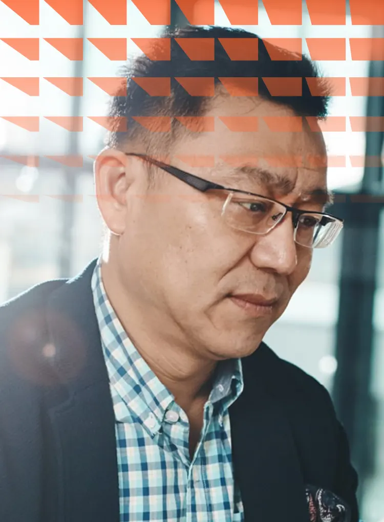 Mature Asian man working on computer in bright office