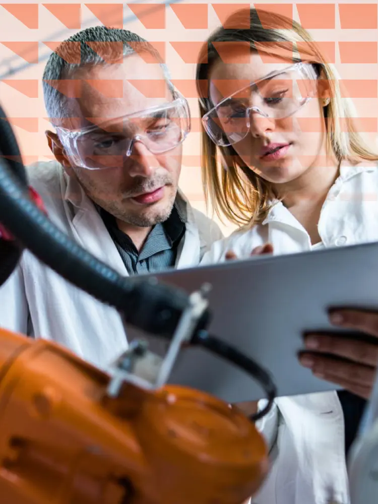 Two lab engineers working together on machinery in a laboratory