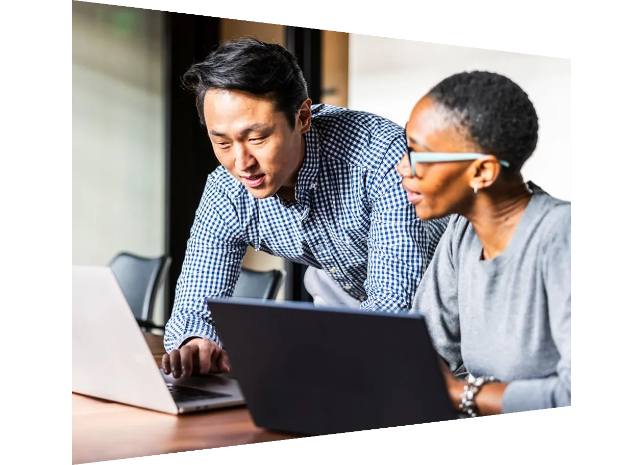 Business colleagues working on laptops in modern conference room