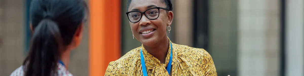 Dos maestras sentadas a una mesa, conversando.