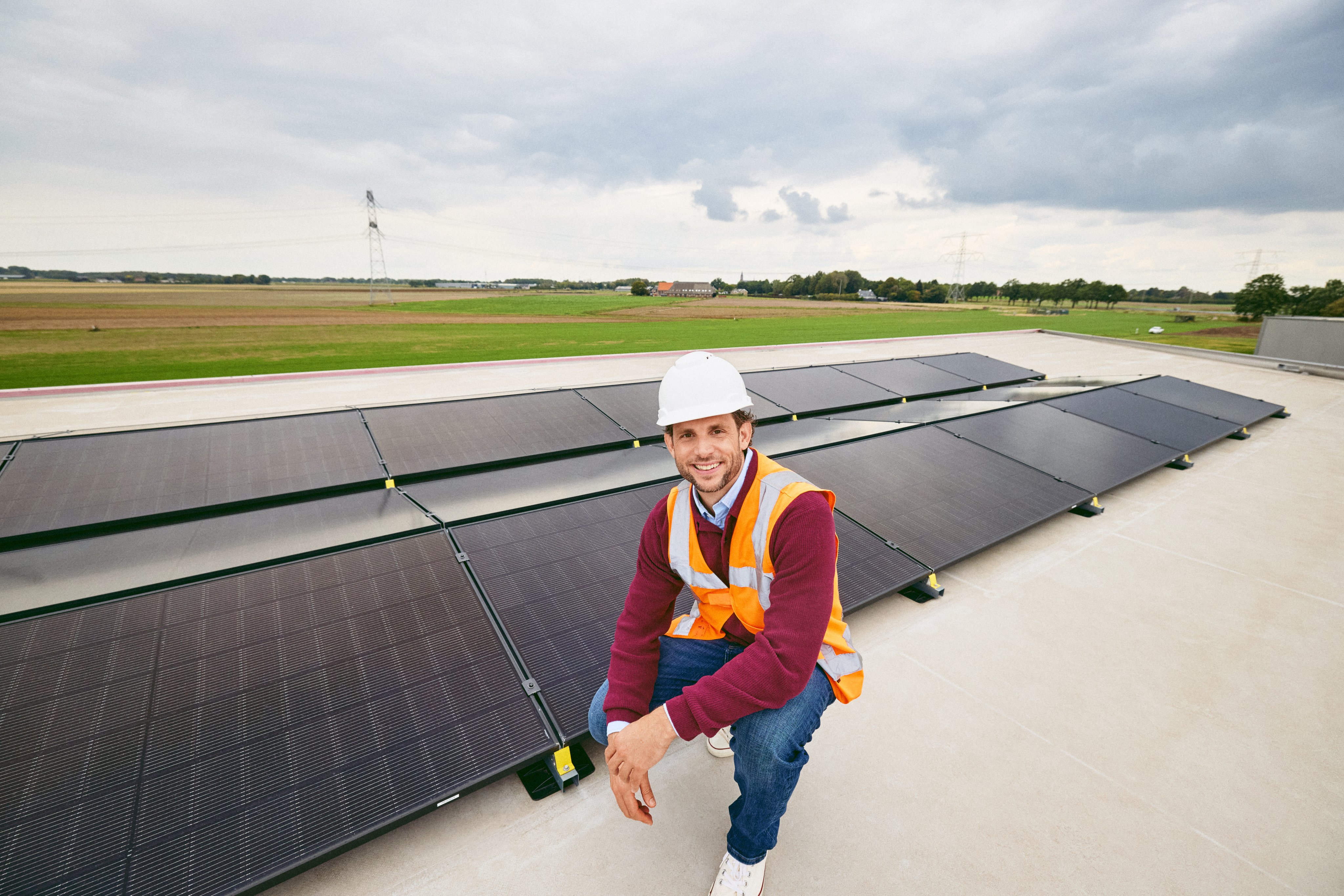 Eric-Jan hurkend naast een zonnepaneel