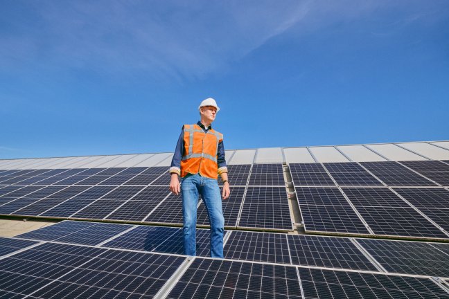 John staat naast zonnepanelen