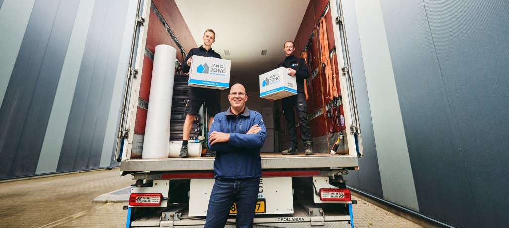 Jan staat bij een verhuiswagen