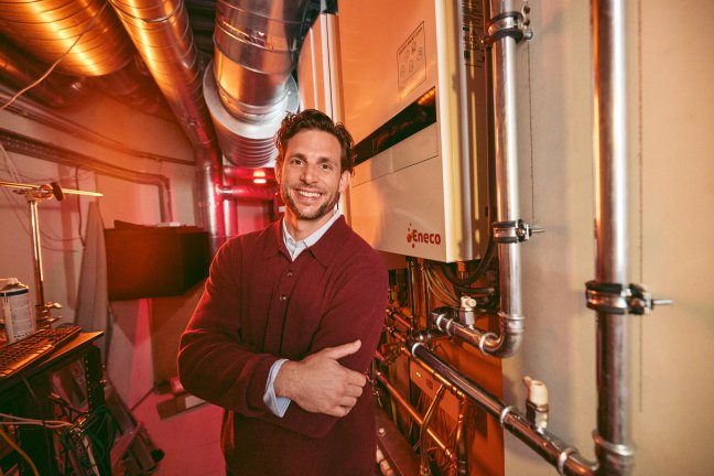 Eric-Jan staat naast een warmtepomp