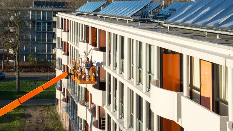Hoogwerkers verven een balkon