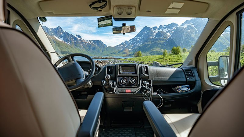 Utsikt fra innsiden av en bobil mot fjell og natur.