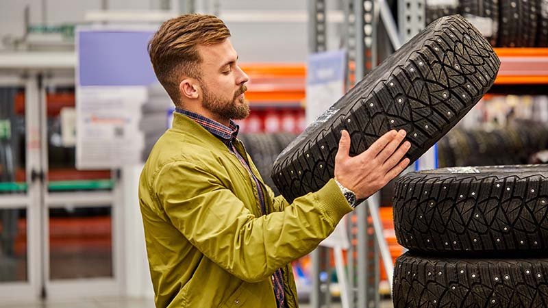 En mann ser på ett piggdekk