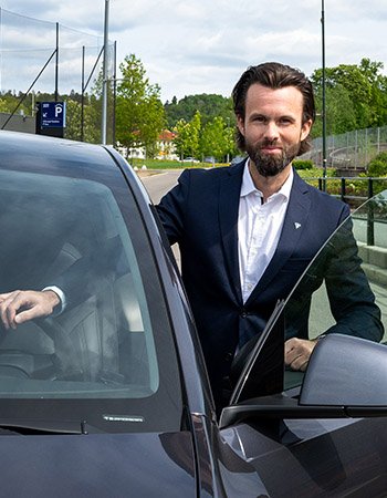 Thomas Iversen, jurist i Forbrukerrådet, står ved førerdøren på en bil.