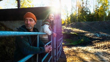 Far og datter som skuer utover gården.