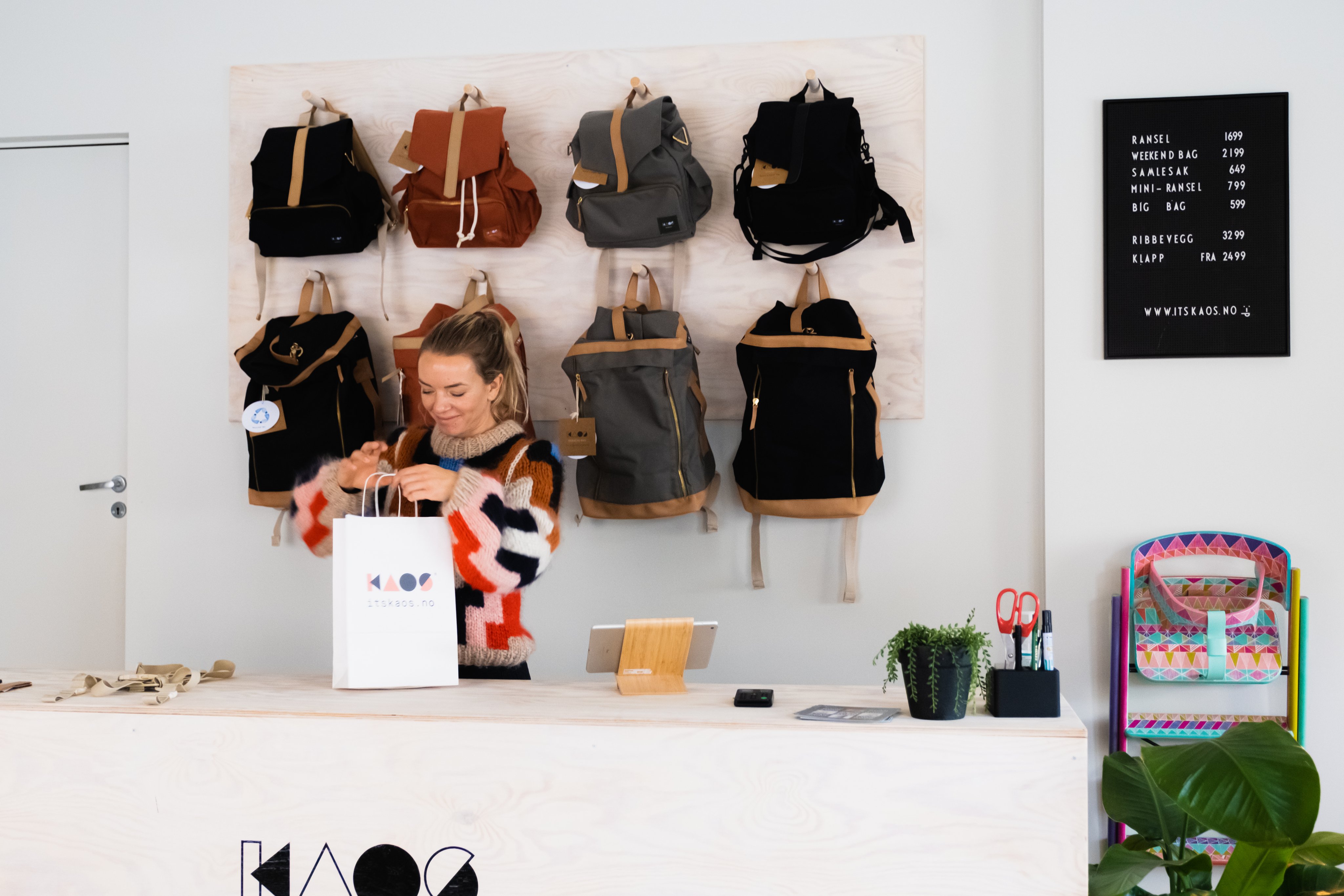 Dame som jobber bak disken i en liten bedrift som selger sekker.