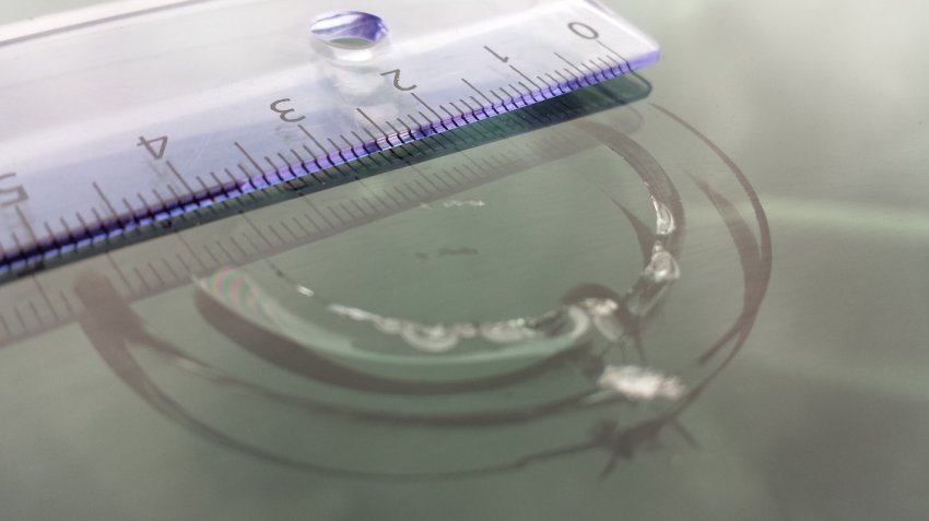 En linjal ligger oppå en sprekk i frontruta på bilen.