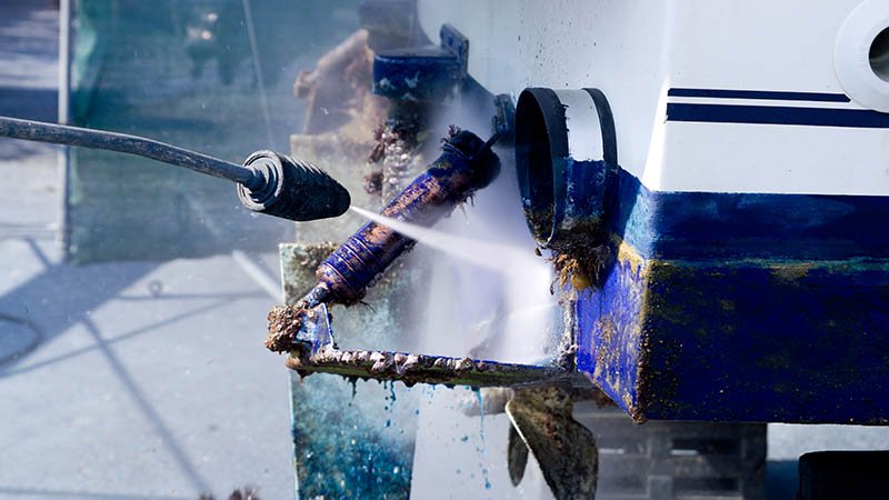Høytrykksspyler rengjør undervannsdeler på en båt.