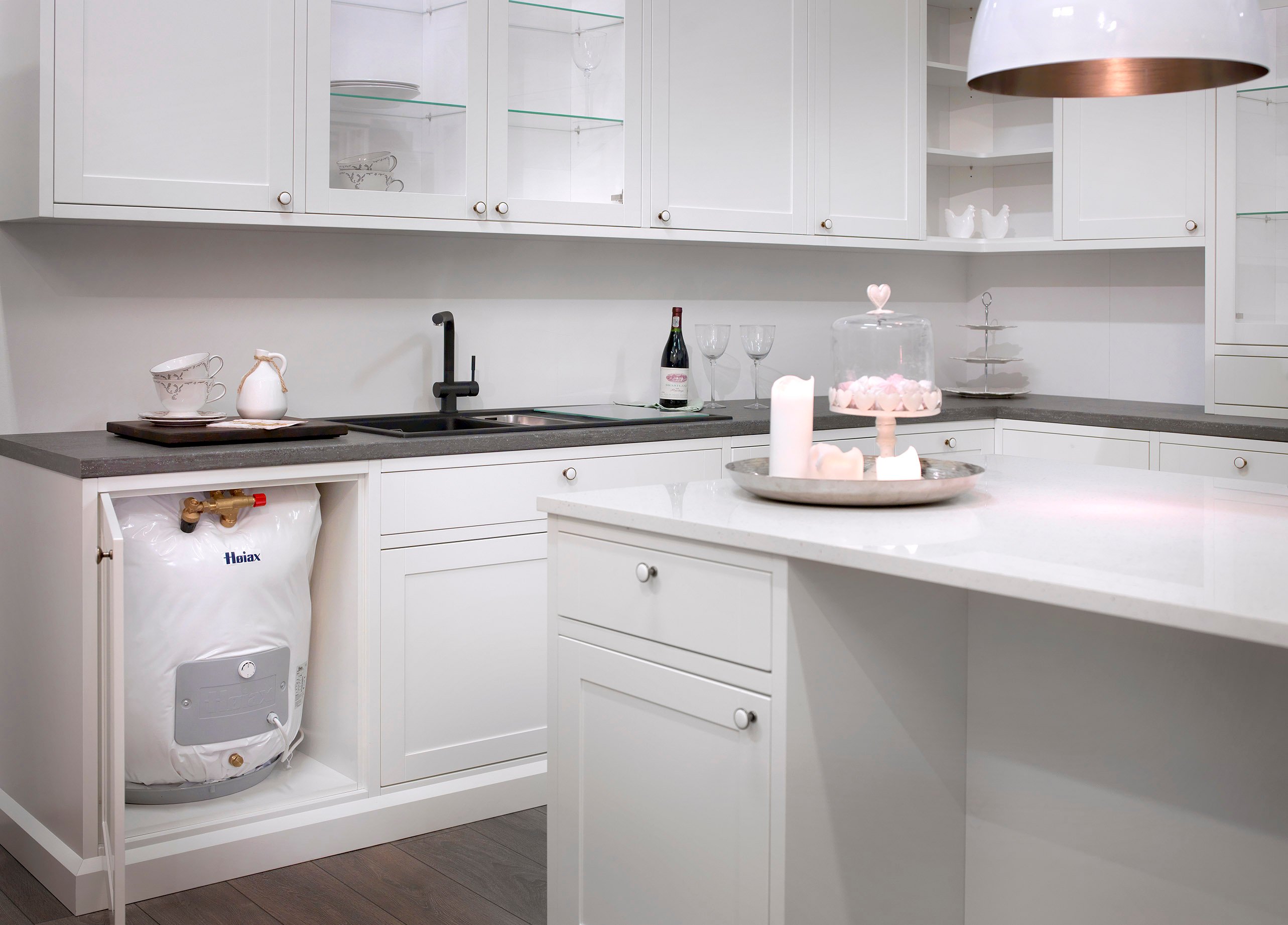 Bilde av et kjøkken med varmtvannsbereder under kjøkkenbenken.