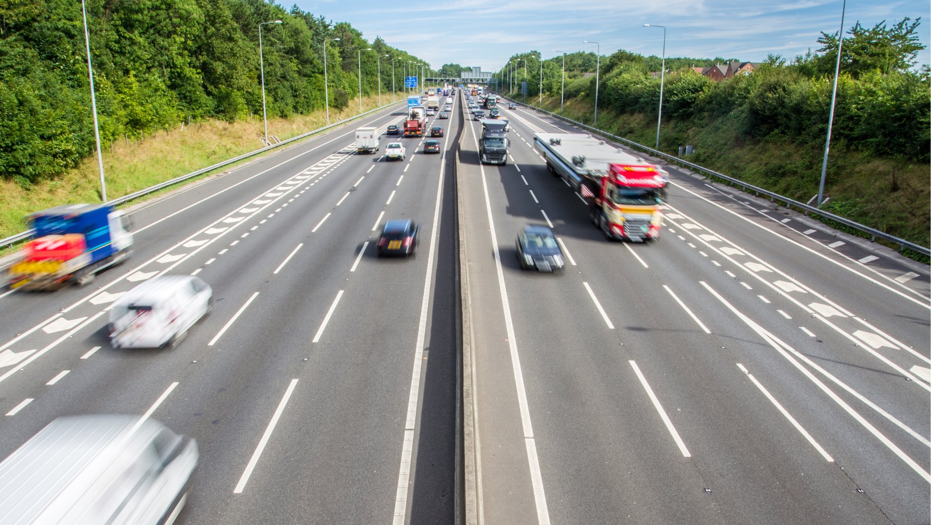 Seksfelts motorvei  med mye trafikk, sett fra en overgang over veien.