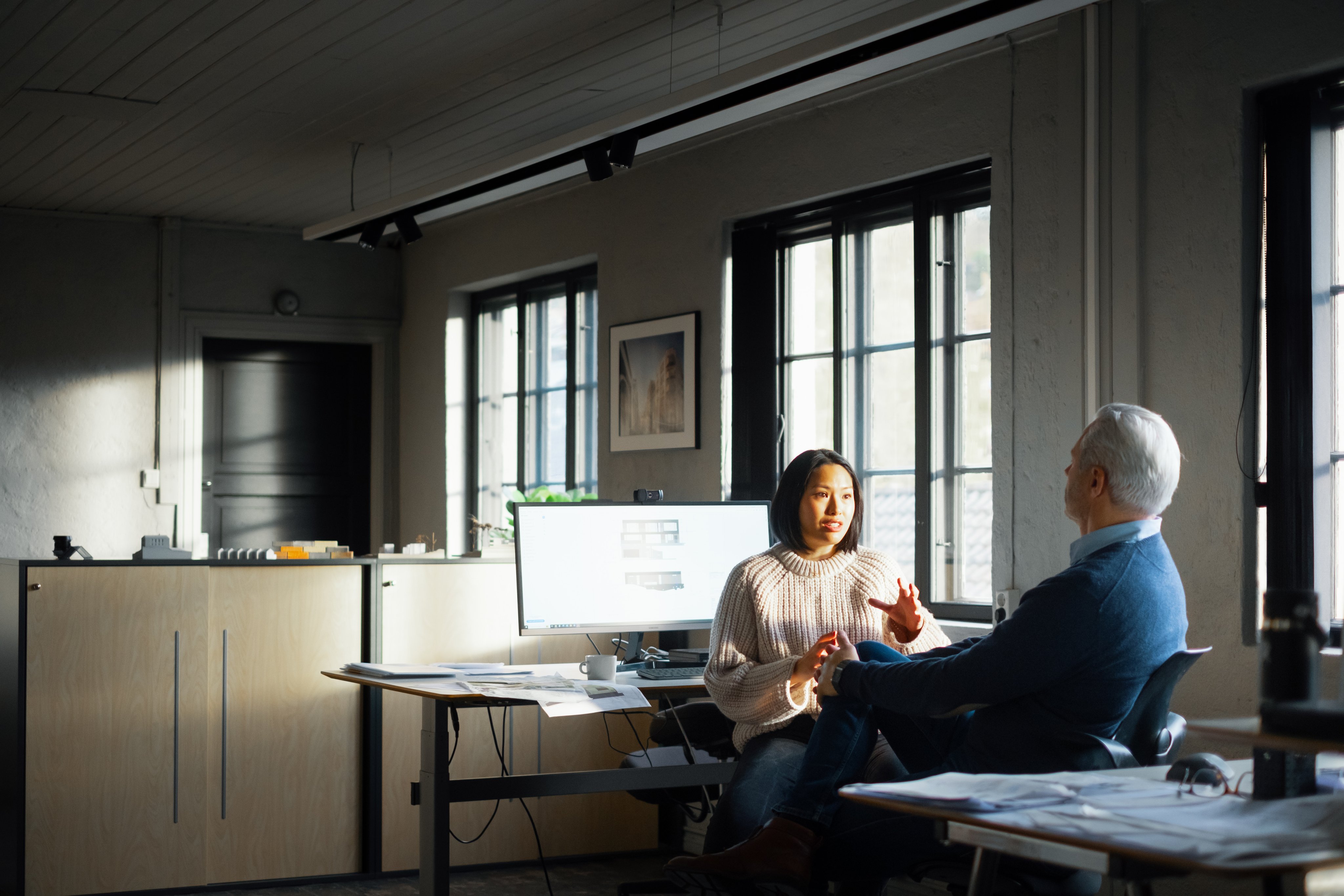 To ansatte som samarbeider i et kontorlandskap. 