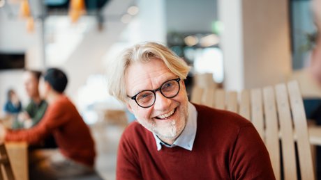 Eldre mann smiler til kamera