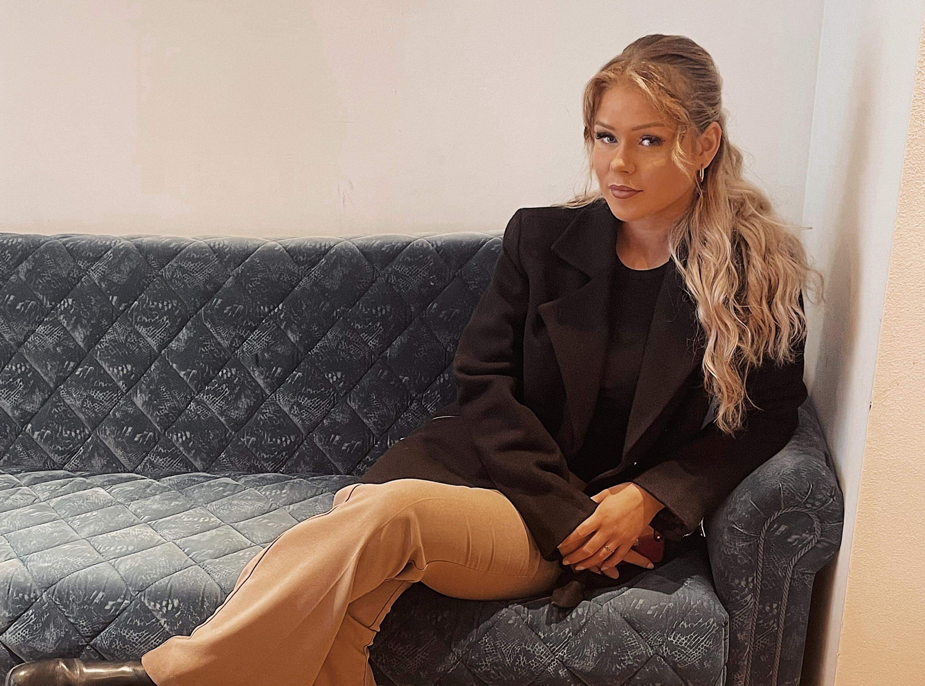 Portrettbilde av Kristin Lode som sitter i en sofa