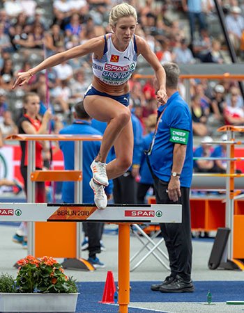 Karoline Bjerkeli Grøvdal hopper over en hekk under en friidrettskonkurranse