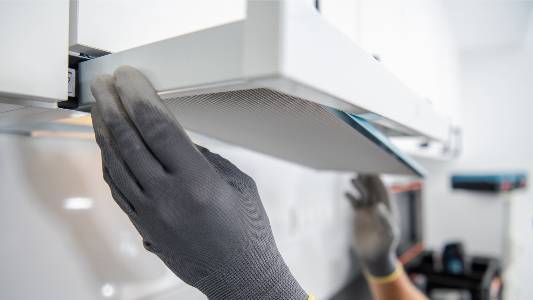 En person vasker en kjøkkenvifte.