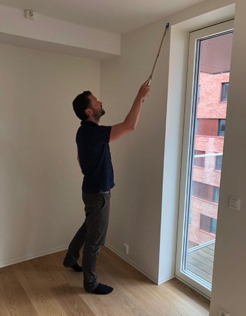 Takstmann inspiserer en ny bolig ved hjelp av tommestokk.