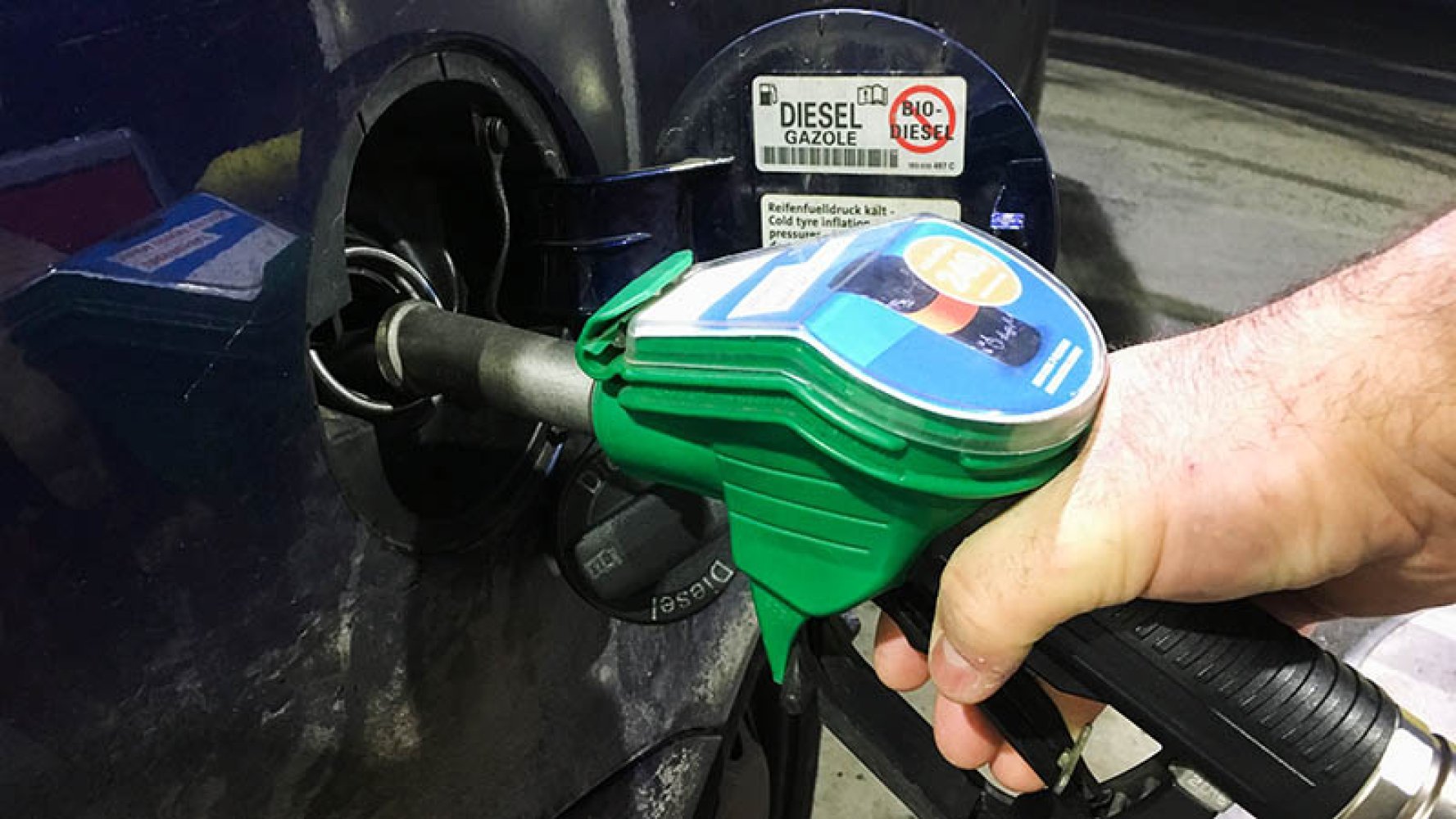 En person fyller bensin med en bensinpumpe.