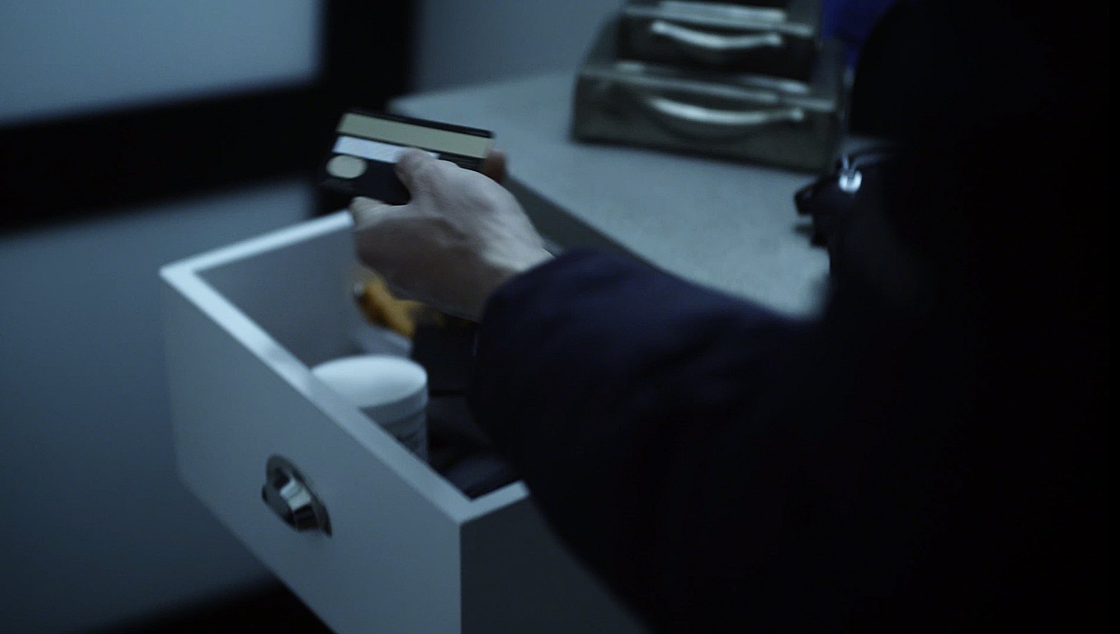 En innbruddstyv stjeler et bankkort fra en skuff.
