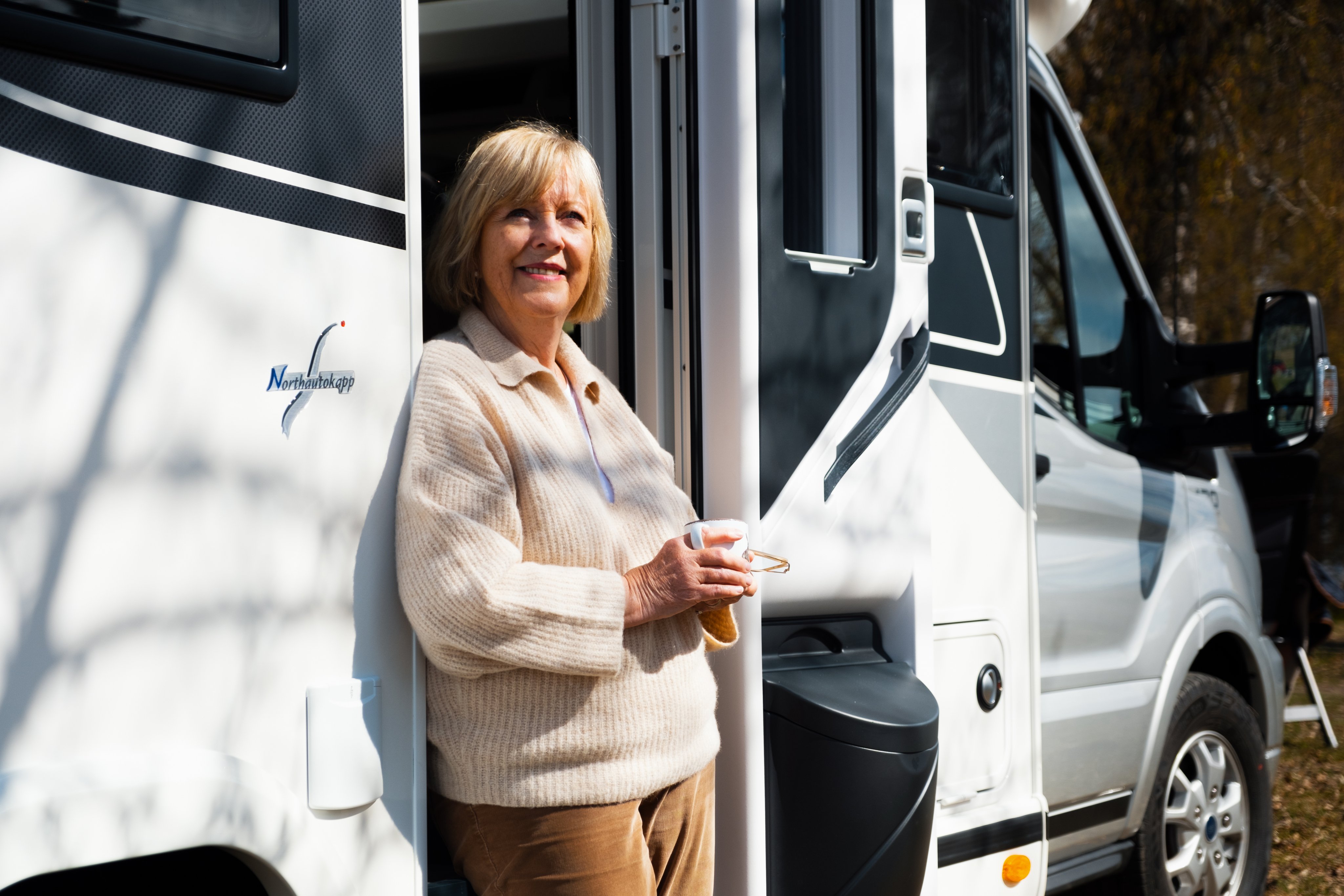 Illustrasjonsfoto når bør man gå av med pensjon. Bestemor som står utenfor bobil.