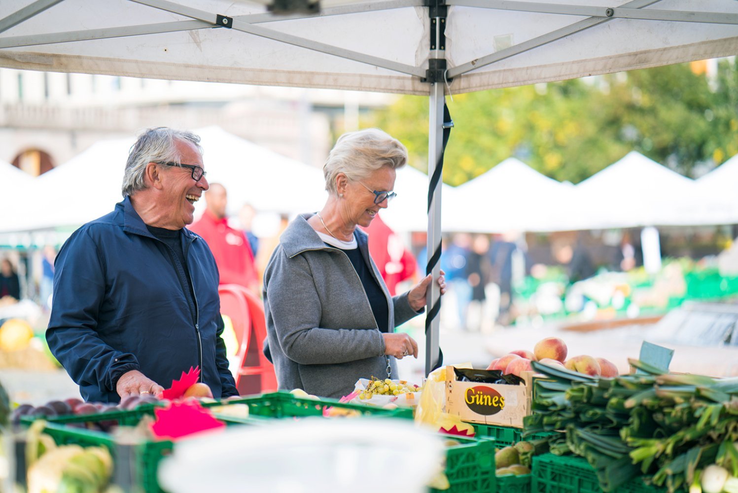Et eldre par handler mat på et matmarked på Youngstorget i Oslo.
