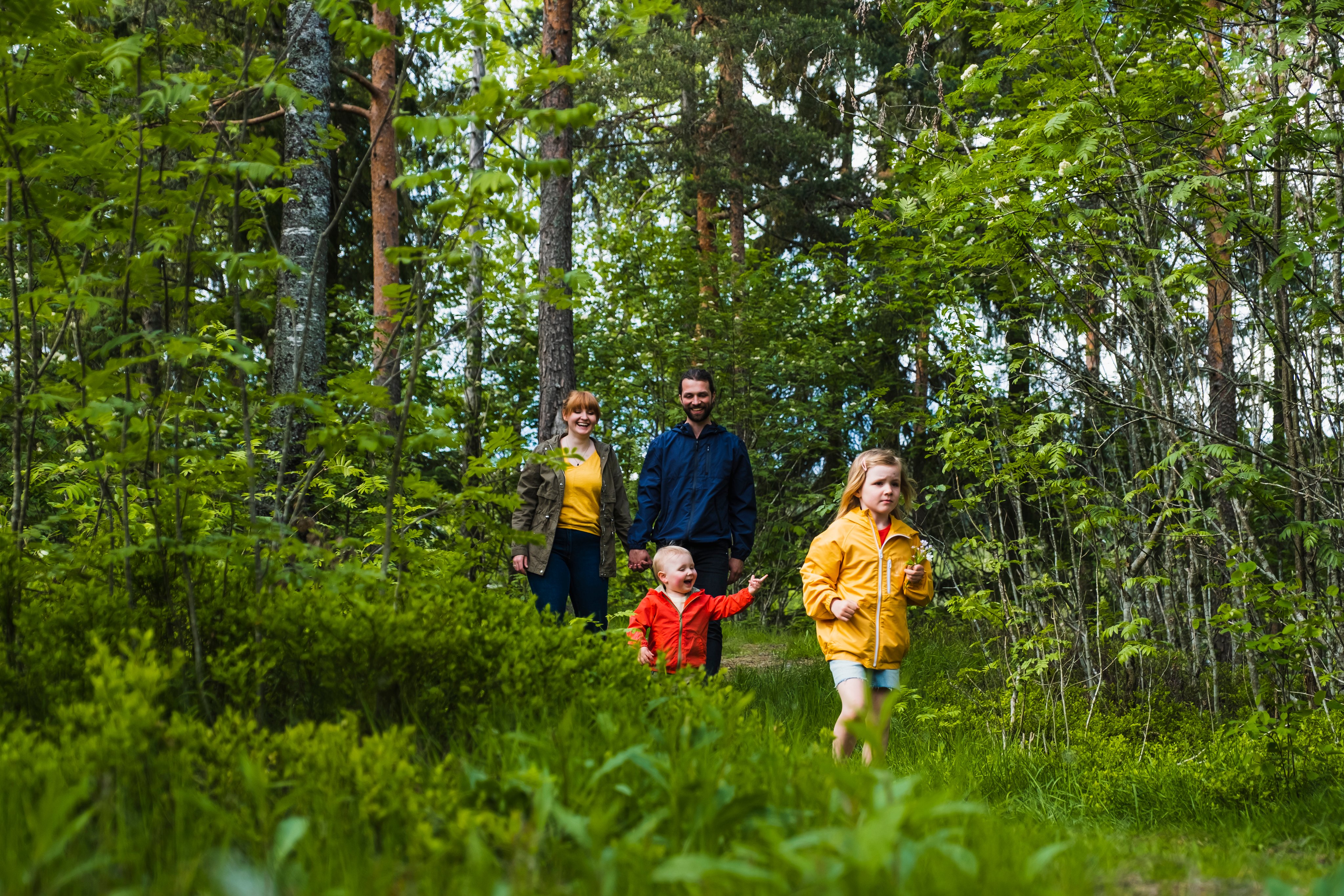 Mor, far og to små barn på skogstur