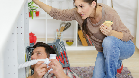 En mann og en dame med verktøy i hendene ser rådville på hverandre.